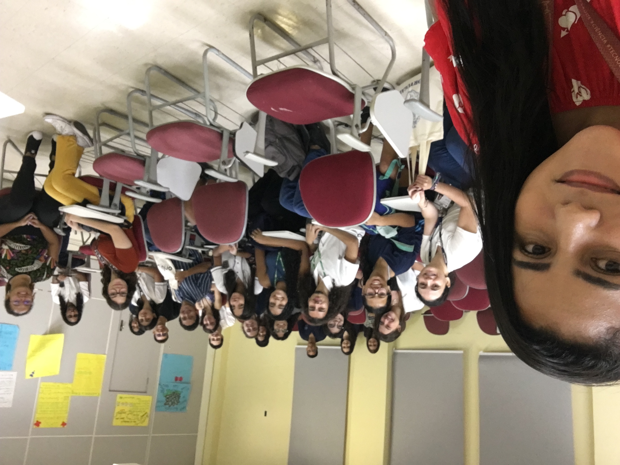 estudantes sentados de frente a computadores e os professores na frente explicando o conteúdo.