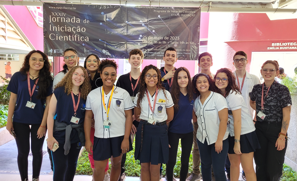 estudantes da Etapa Iniciação do Provoc Rio posam pra foto na frente do banner do evento.